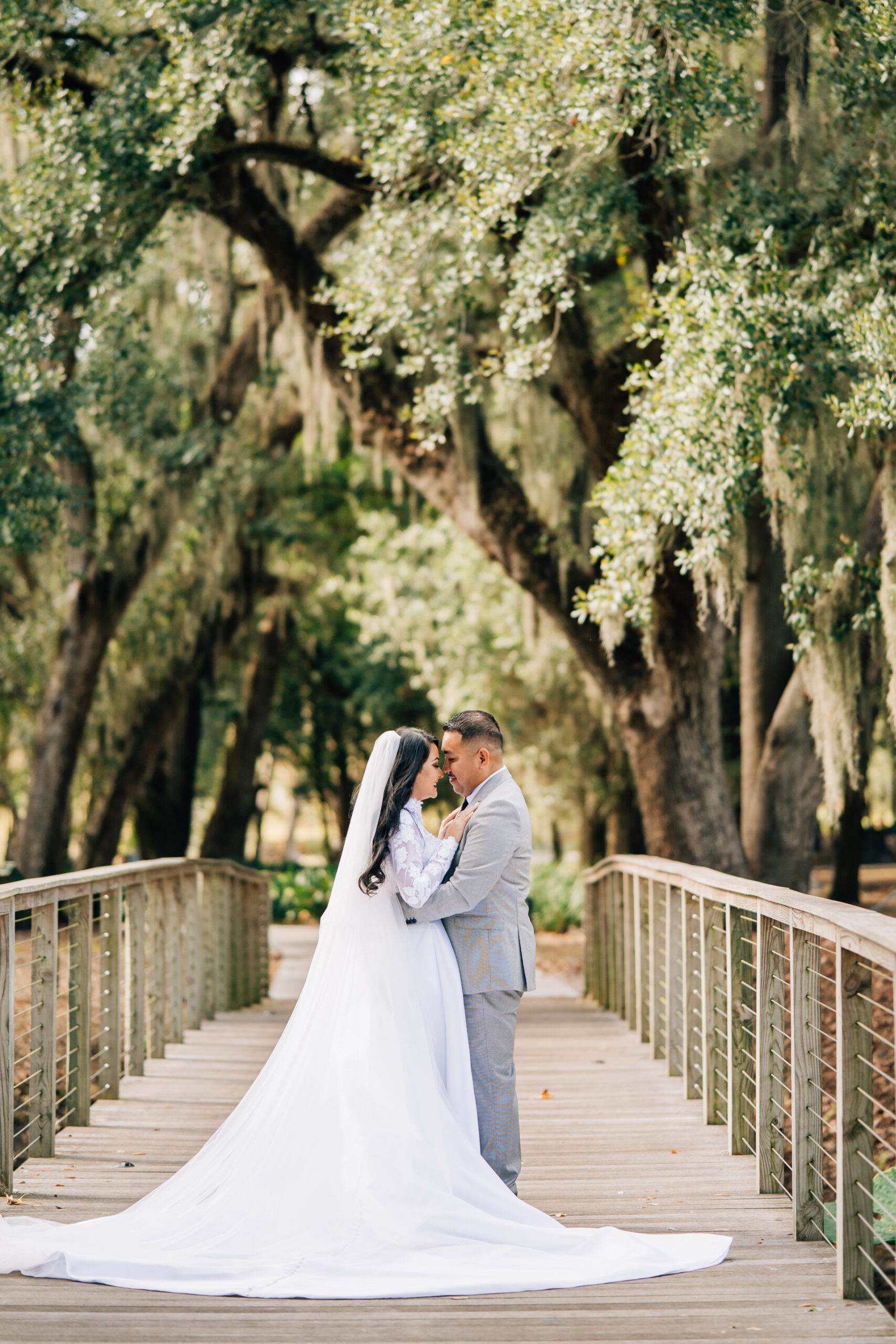 For the couple in the meadow: "Utah wedding photographers capture a bride and groom in a sun-drenched clearing over a bridge in Lakeland, Florida, during a January wedding shoot."