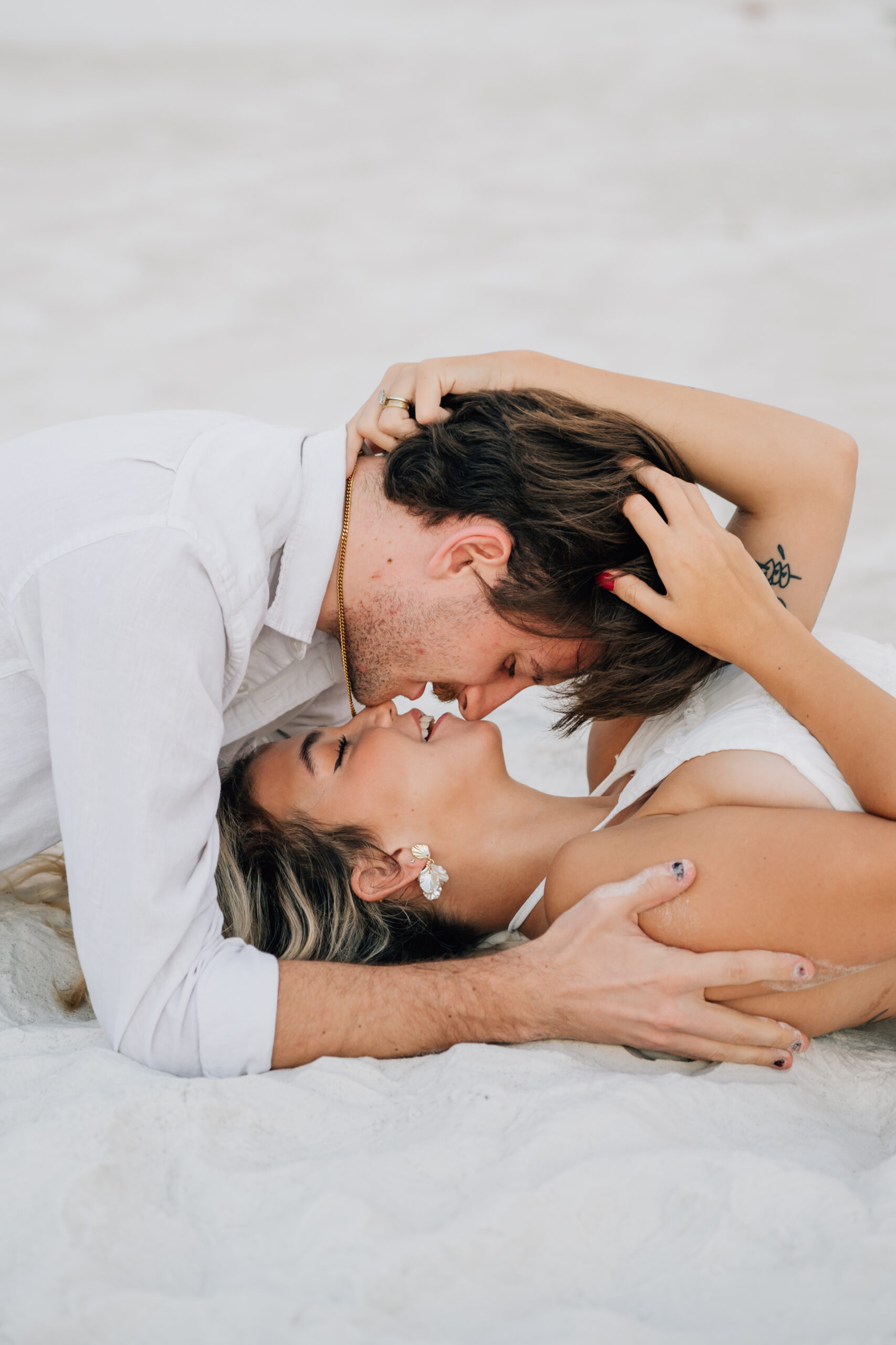 For the couple walking by the water: "Destination Utah wedding photographers capture Nicole and Alex walking along the white sand shores of Pensacola Beach, Florida, during their engagement shoot."