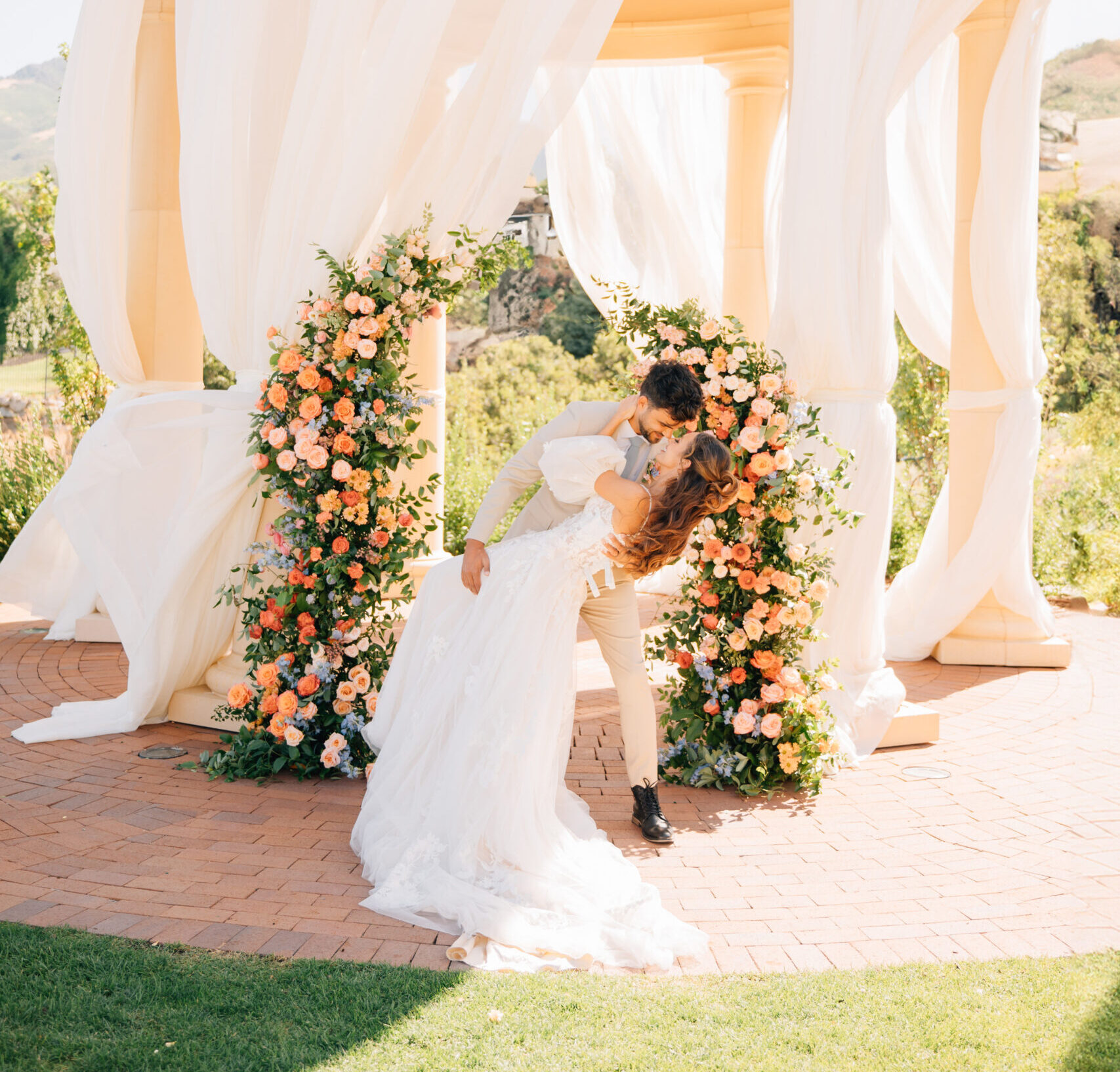 "A stylish couple posing in front of the sweeping valley views and iconic rotunda at Siempre wedding venue in Draper, Utah."