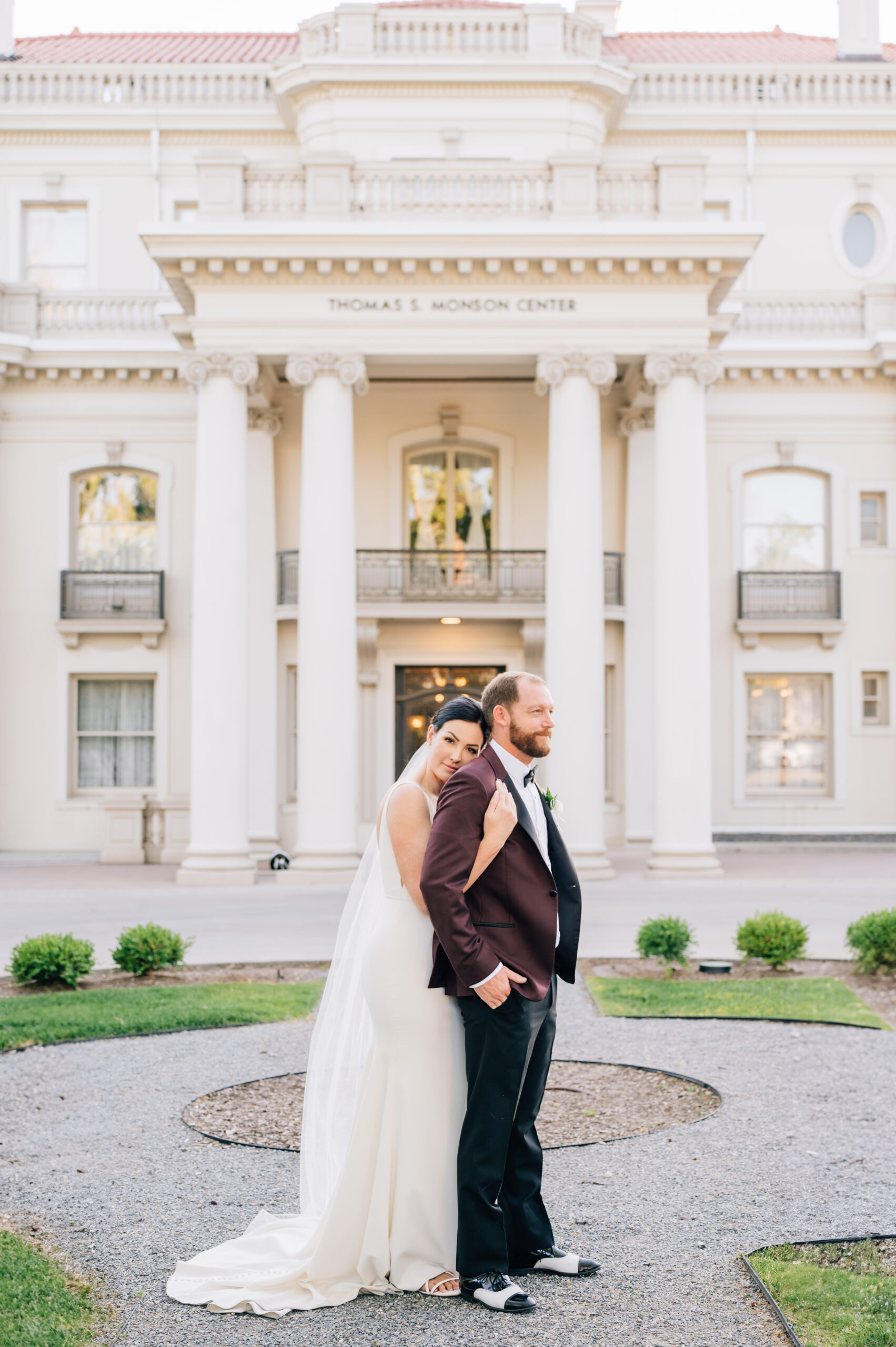 Detail of the suit: "A handsome groom in a tailored maroon suit with black trim and custom wedding shoes at the Thomas S. Monson Center."